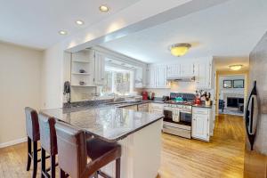 a kitchen with white cabinets and a large island at Hazel Retreat in Barnstable