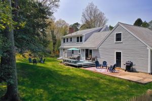 a house with a backyard with a deck and a patio at Hazel Retreat in Barnstable