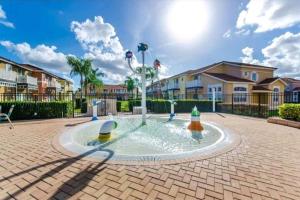 una fuente en medio de un patio con casas en Fabulous, Quiet Family Resort Vacation Home, South Facing Pool, at Lake Berkley Resort, Near Disney, SeaWorld, en Kissimmee