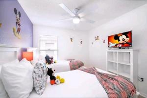 a bedroom with two beds and a ceiling fan at Fabulous, Quiet Family Resort Vacation Home, South Facing Pool, at Lake Berkley Resort, Near Disney, SeaWorld in Kissimmee
