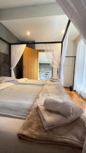 a bedroom with a large bed with white curtains at Town hostel in Peje