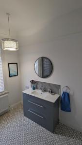 een badkamer met een wastafel en een spiegel bij Seaside Escapes - with relaxing hot tub! in Scarborough