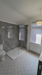 a bathroom with a shower and a toilet at Seaside Escapes - with relaxing hot tub! in Scarborough
