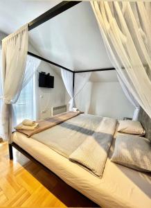 a bedroom with a large bed with curtains at Town hostel in Peje