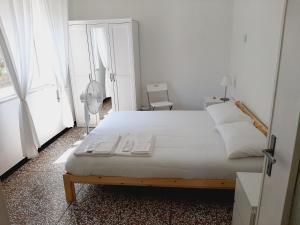 a bedroom with a large white bed and a window at WONDERFUL NOLI - appartamento Noli Liguria Italia in Noli