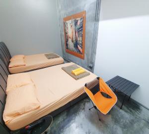 a room with two beds and a table and a painting at Lot 85 Seremban Town New Cozy Homestay Lobak Roomstay in Seremban
