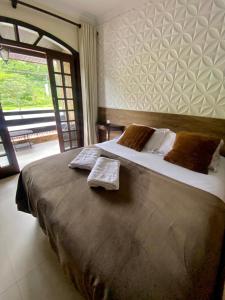 a bedroom with a large bed with two pillows at Pousada Estrela Guia in Aparecida
