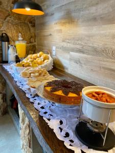 a table with pies and other food on it at Pousada Estrela Guia in Aparecida