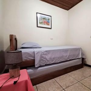 a bedroom with a bed with a picture on the wall at Casa Cafetal Aeropuerto in Alajuela