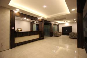 a lobby with a waiting room with a clock on the wall at Hotel Yog Palace Newly Renovated in Shirdi