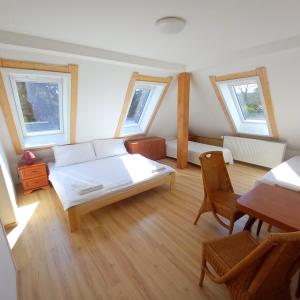 スタレー・スプラヴィにあるPenzion Diana Máchovo jezeroのベッド、テーブル、窓が備わる客室です。