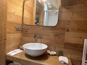 een badkamer met een wastafel en een spiegel bij Chalet La Petite Ourse in Hohrod