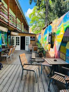 a deck with chairs and tables and a mural at Central Hostel Cluj in Cluj-Napoca