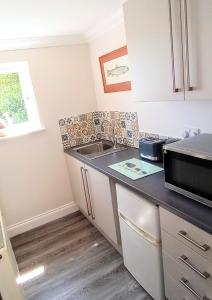 a kitchen with a sink and a microwave at Oakcroft in Sidmouth