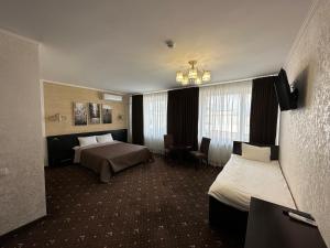 a hotel room with two beds and a chandelier at Hotel Merry Club in Malyye Khutora