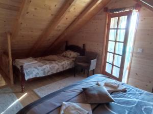 a bedroom with a bed and a chair in a cabin at Bellavista in Čukovići