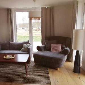 Sala de estar con 2 sofás y mesa de centro en Haus am Seeufer, en Rheinsberg
