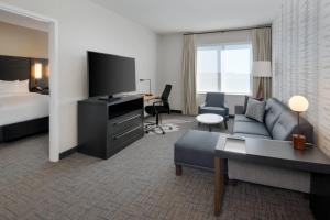 a hotel room with a couch and a bed and a television at Residence Inn by Marriott Indianapolis Keystone in Indianapolis