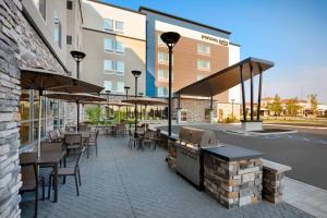 een patio met tafels en stoelen en een grill bij Residence Inn by Marriott Indianapolis Keystone in Indianapolis