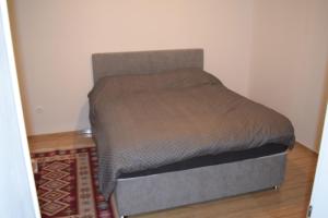 a bed in a small room with a gray mattress at Apartman Maga in Čapljina