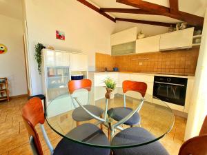 uma cozinha com uma mesa de vidro e cadeiras laranja em Apartments Roko em Zadar