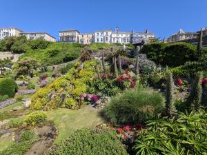 Un jardín con flores y edificios en una colina. en The Sea Shack, en Ventnor