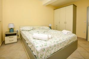 a bedroom with a large bed with towels on it at Apartments Villa J i M by the sea in Rogoznica