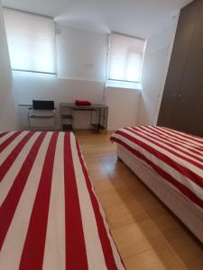 2 camas en una habitación con rayas rojas y blancas en Port Caneta Hendaye appt 55 m class 2 étoiles, en Hendaya