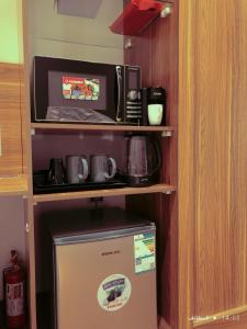 a microwave and a refrigerator in a room at مساكن خاصة بتصميم فندقي ووصول ذاتي in Taif