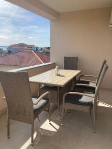 a wooden table and chairs on a balcony at Apartman Hmelina in Vrsi