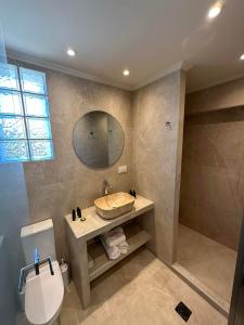 a bathroom with a sink and a toilet and a mirror at Sea Side Studios in Tsilivi