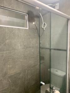 een badkamer met een glazen douche en een toilet bij Lindo Flat em Ponta Negra - Natal in Natal