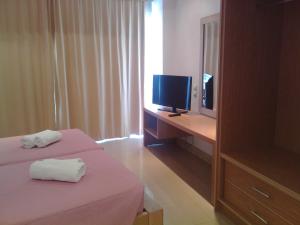 a hotel room with two beds and a television at Maria Apartments in Agia Pelagia