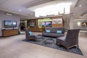 a lobby with two chairs and a couch and a tv at Courtyard by Marriott St. John's Newfoundland in St. John's