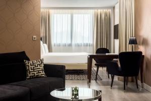 a living room with a couch and a table at AC Hotel Paris Porte Maillot by Marriott in Paris