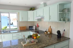 a kitchen with white cabinets and a bowl of fruit on the counter at Horta la Vita in Horta
