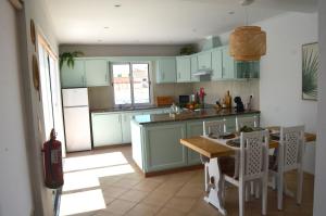 a kitchen with green cabinets and a table and chairs at Horta la Vita in Horta +39 photos
