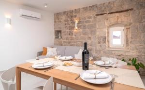 a dining room with a table with a bottle of wine at Villa Moscatello in Hvar