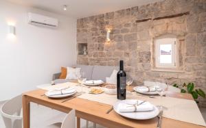 Un comedor con una mesa con una botella de vino. en Villa Moscatello, en Hvar