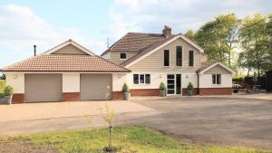 une grande maison blanche avec un garage dans l'établissement Oakcroft, à Sidmouth