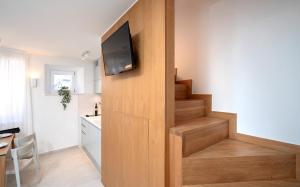 Una sala de estar con una escalera con un televisor en una pared. en Villa Moscatello, en Hvar