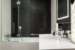 a bathroom with two sinks and a shower at AC Hotel Paris Porte Maillot by Marriott in Paris