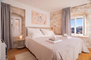 sypialnia z dużym łóżkiem z ręcznikami w obiekcie Villa Moscatello w Hvarze