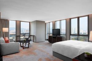深セン市にあるJW Marriott Hotel Shenzhenのベッドとテレビが備わるホテルルームです。