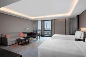 ein Hotelzimmer mit einem Bett, einem Sofa und einem Schreibtisch in der Unterkunft JW Marriott Hotel Shenzhen in Shenzhen
