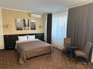 a hotel room with a bed and a table at Hotel Merry Club in Malyye Khutora