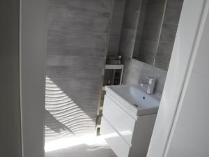 W łazience znajduje się biała umywalka i lustro. w obiekcie Villa Luis w Dziwnowie
