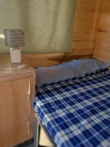 a bed in a room with a blue plaid mattress at Quinta Coki in Pirayú