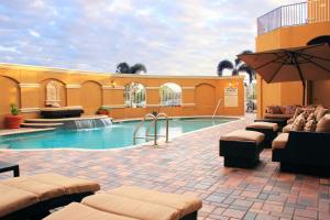 a pool at a hotel with chairs and an umbrella at St. Petersburg Marriott Clearwater in St Petersburg