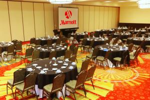 a conference room with tables and chairs and a stage at St. Petersburg Marriott Clearwater in St Petersburg